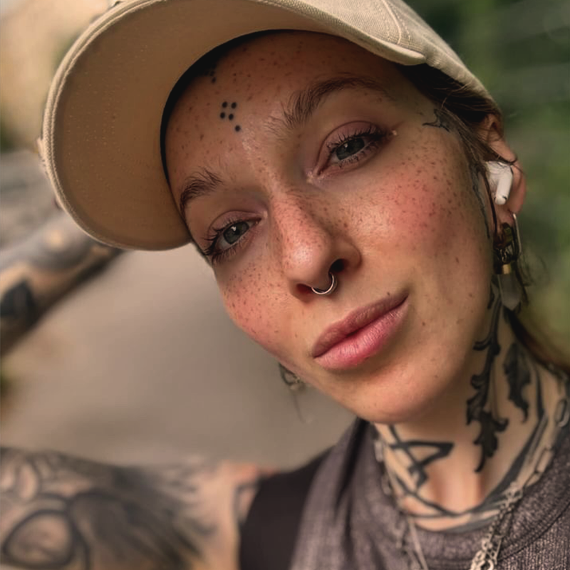 Man sieht eine Nahaufnahme von einem Frauengesicht von Sommersprossen Tattoos.
