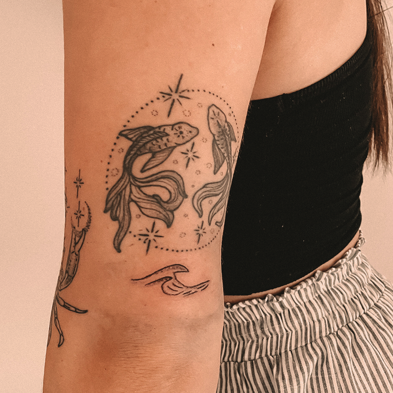 Man sieht einen Oberarm einer Frau mit einem Handpoke Tattoo.